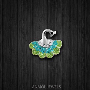 May include: A silver-toned brooch in a peacock design, featuring a fan-shaped body with green and blue crystals. The brooch has a curved top with a small heart-shaped detail and is embellished with clear crystals.