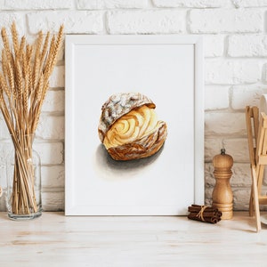 Pode incluir: Pintura em aquarela de um pastel em uma moldura branca. O pastel é de cor marrom dourado com uma leve polvilhada de açúcar de confeiteiro. A pintura é colocada contra uma parede de tijolos brancos, com espigas de trigo.