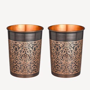 May include: Two copper tumblers with a black finish and a copper-coloured floral design.