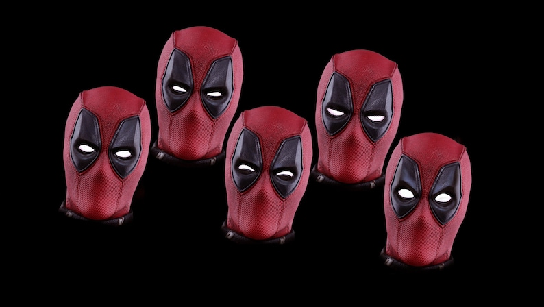 May include: Five red and black Deadpool masks with white eyes. The masks are arranged in a row, with the middle mask slightly higher than the others.