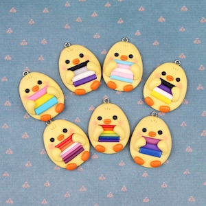 May include: Seven yellow chick charms with different pride flag designs. Each charm has a small loop for attaching to a necklace, bracelet, or keychain.