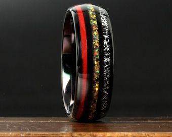 May include: A black ring with a red stripe and a section of iridescent material. The ring has a polished finish and a unique design, suitable for a special occasion or everyday wear.