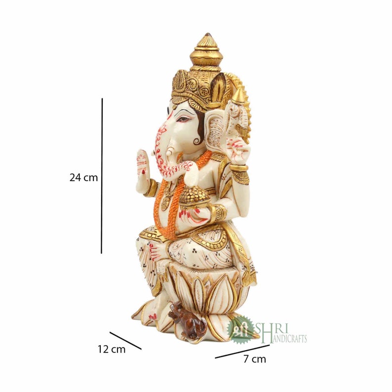 May include: White and gold Ganesha statue sitting on a lotus base with a mouse at its feet. The statue is 24 cm tall, 12 cm wide, and 7 cm deep.