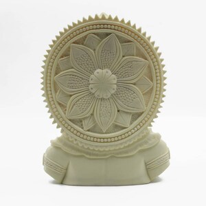 May include: White ceramic sculpture of a deity with a detailed floral design on the back. The sculpture is carved with intricate details and has a smooth, matte finish.