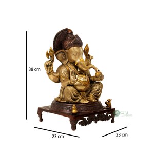 May include: A gold and brown brass statue of Ganesha, the Hindu god of wisdom and prosperity, sitting on a wooden base. The statue is 38 cm tall, 23 cm wide, and 23 cm deep.
