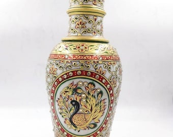 Könnte beinhalten: Eine weiße Marmorvase mit goldenen und roten Akzenten. Die Vase ist mit einem Pfauenmuster verziert und hat einen runden Boden. Die Vase ist etwa 30 cm hoch.