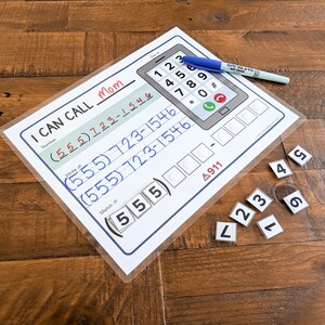 May include: A white and blue printable phone activity sheet with the text "I Can Call Mom" and a phone with a number pad. The sheet includes a section for writing phone numbers and a section for matching numbers. There are also small white squares with numbers on them.