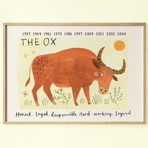 May include: A framed art print featuring an orange ox illustration. The text "THE OX" is above the ox, with years listed above. Below the ox are the words "Honest, Loyal, Responsible, Hard-working, Logical".