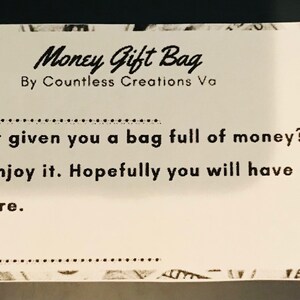 May include: A white card with black text that reads "Money Gift Bag" by Countless Creations Va. The card has a dotted line for a name and a message that reads "Has anyone ever given you a bag full of money? Well if this is your first one, enjoy it. Hopefully you will have many more to come in the future."