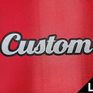May include: A red fabric with the word "Custom" embroidered in white with a black border. The letter "L" is in a black triangle in the lower right corner.