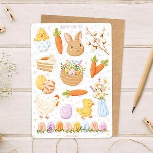 Może przedstawiać: Arkusz naklejek z ilustracjami wielkanocnymi, w tym zajączkiem, marchewkami, pisklętami, jajkami i kawałkiem ciasta. U góry napis "Happy Easter". Arkusz leży na brązowej kartce.