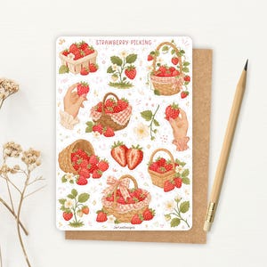 May include: A sticker sheet titled STRAWBERRY PICKING featuring various illustrations of red strawberries in woven baskets, a strawberry plant, and hands holding strawberries. The design includes small pink hearts and floral accents on a white background.