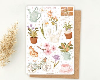 Peut inclure: Une planche d'autocollants intitulée SPRINGTIME avec des illustrations d'un arrosoir bleu clair, de fleurs orange, d'une enveloppe brune, de plantes en pot, d'un haut blanc, d'un papillon, de cerisiers en fleurs, d'un vélo, d'un crocus violet et d'une tasse à thé rose.