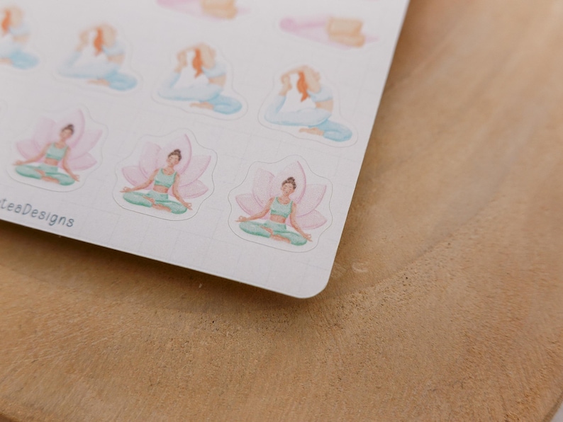 May include: A sheet of stickers featuring watercolor illustrations of yoga poses. The stickers depict figures in various yoga positions, including seated lotus and reclining poses, in soft pastel colors. The stickers are on a white background.