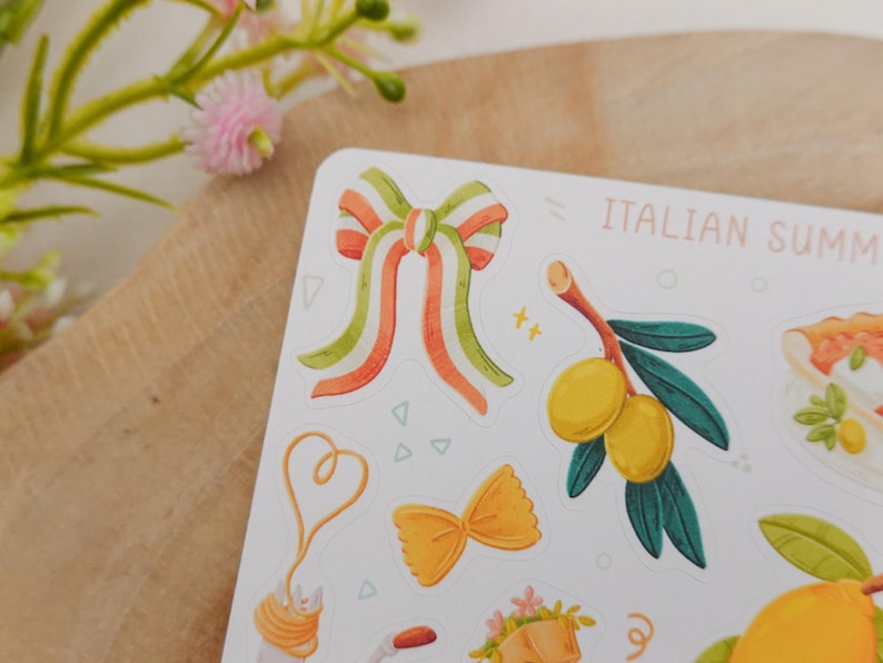 May include: A sticker sheet with Italian summer-themed illustrations. The sheet features a bow with orange, green, and white stripes, olive branch, pasta, and the text "ITALIAN SUMMER".