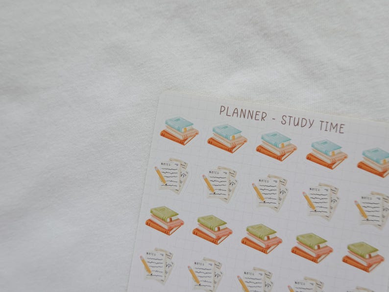 May include: A sheet of planner stickers with watercolor illustrations. The stickers feature stacks of books in various colors and sheets of paper with pencils. The text "PLANNER - STUDY TIME" is at the top.