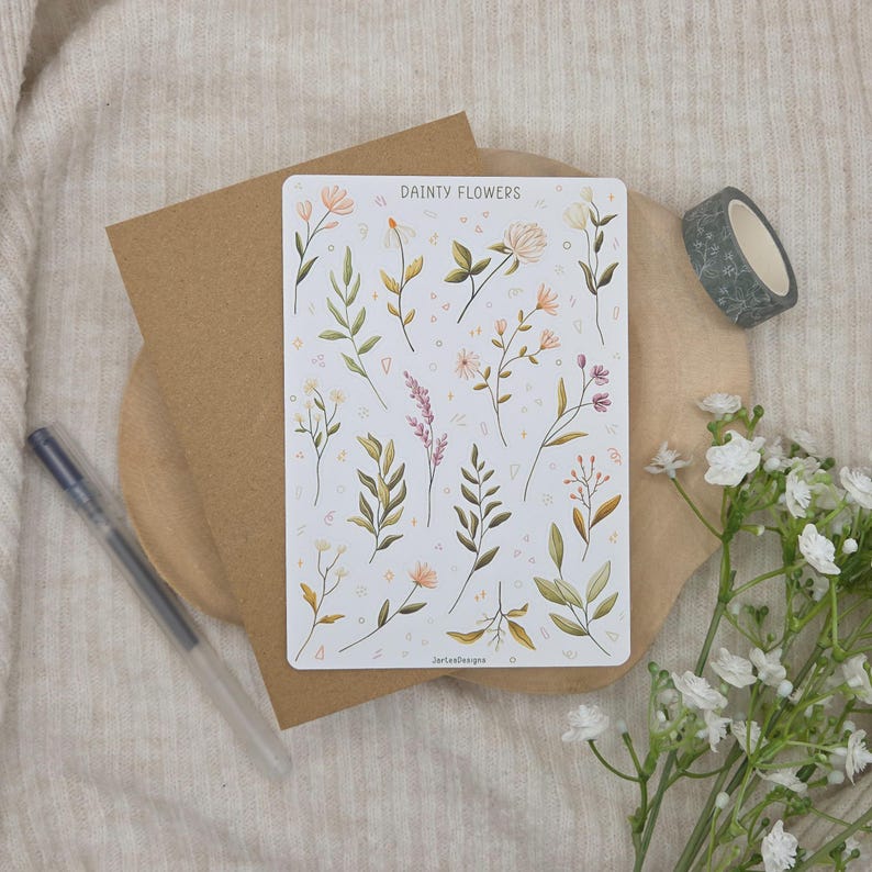 May include: A rectangular sticker sheet titled DAINTY FLOWERS featuring various botanical illustrations of wildflowers, leaves, and stems in muted green, pink, and yellow tones, set against a white background with small geometric shapes.