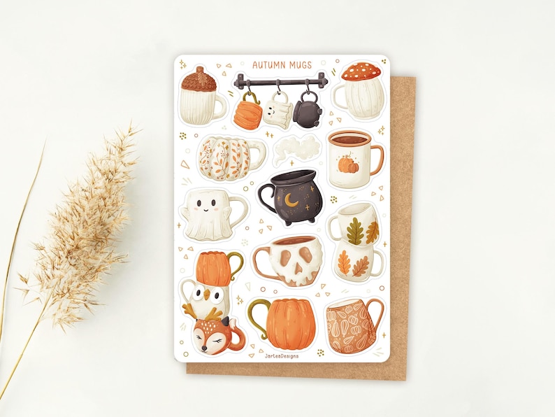 May include: A sticker sheet with illustrations of autumn-themed mugs. Designs include a mushroom, pumpkin, ghost, and skull. The text "AUTUMN MUGS" is at the top. The sticker sheet is on a brown card.