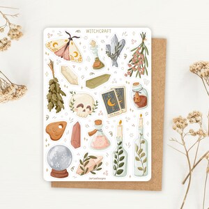 May include: A sticker sheet titled WITCHCRAFT featuring illustrations of a moth, crystals, a skull, tarot cards, potion bottles, candles, herbs, and a crystal ball. The sheet includes various botanical and mystical elements in soft, muted tones.