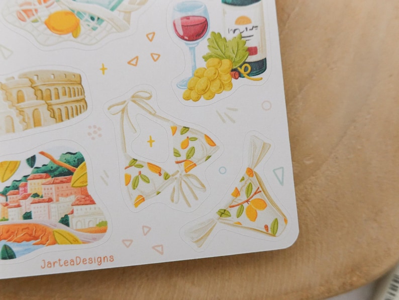 May include: A sheet of stickers featuring illustrations of summer and travel themes. Includes a bikini with a lemon pattern, a glass of red wine, a bottle of wine, grapes, and the Colosseum.