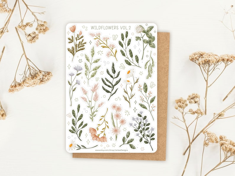 May include: A rectangular sticker sheet titled WILDFLOWERS VOL. 2 featuring various watercolor-style illustrations of green foliage, stems, and flowers in shades of pink, white, and blue, accented with small star and circle decorative elements.