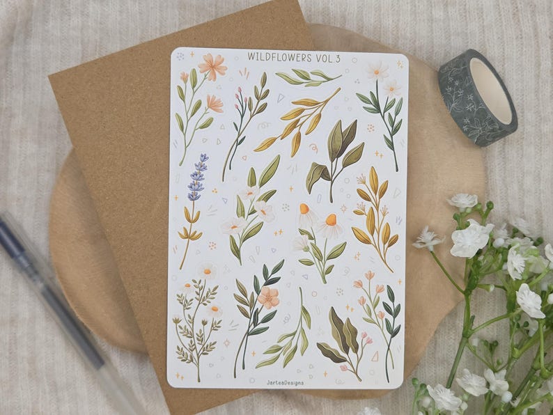 May include: A rectangular sticker sheet titled WILDFLOWERS VOL 3 featuring various botanical illustrations including lavender, daisies, and leafy branches in shades of green, yellow, and soft orange, accented with small white star and dot patterns.