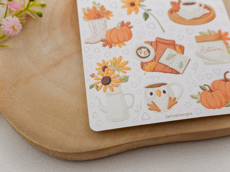 May include: A sheet of fall-themed stickers featuring pumpkins, sunflowers, coffee, and a sweater. The stickers have a white background with a variety of fall-related illustrations. The text "JarlesDesigns" is visible on the bottom right of the sticker sheet.