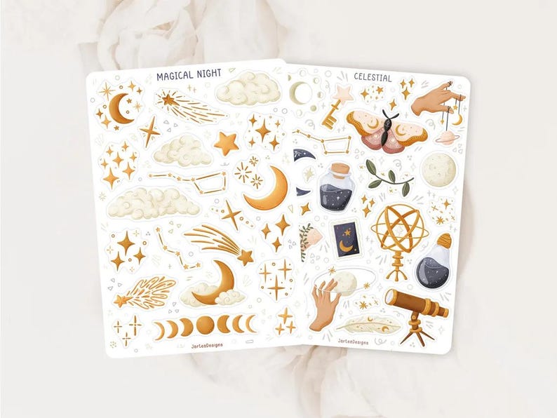 Puede incluir: Dos hojas de pegatinas etiquetadas como MAGICAL NIGHT y CELESTIAL con ilustraciones doradas y marrones de lunas crecientes, estrellas, estrellas fugaces, nubes, una polilla, un telescopio, un globo terr&aacute;queo, frascos y manos con objetos.