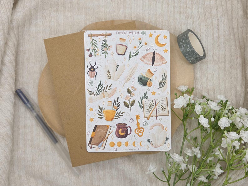 May include: A rectangular sticker sheet titled Forest Witch featuring various illustrations including a beetle, crystals, a moth, a potion bottle, a book, a key, a mug, and moon phases in earthy tones of brown, green, yellow, and soft pink on a white background.
