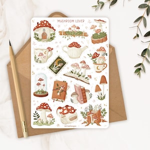 May include: A rectangular sticker sheet titled MUSHROOM LOVER featuring various illustrations of red and white mushrooms, including a mushroom house, a teapot, books, mugs, and a glass cloche. The sheet includes the text JartesDesigns at the bottom.