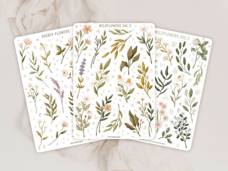 May include: Three sticker sheets featuring botanical illustrations of wildflowers and foliage. The sheets are labeled Dainty Flowers, Wildflowers Vol. 3, and Wildflowers Vol. 2. The designs include lavender, daisies, and various green leaves in soft tones.