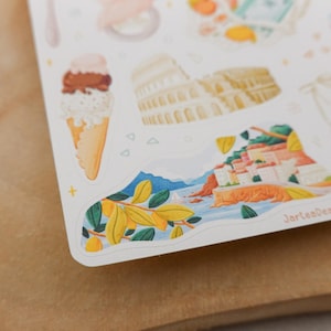 May include: A sheet of stickers featuring illustrations of Italian landmarks and food. The stickers include an ice cream cone, the Colosseum, and a coastal town scene. The stickers are in a watercolor style.