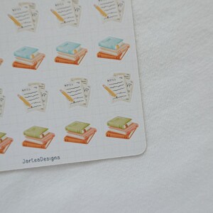 May include: A sheet of stickers featuring illustrations of books, notepads, and pencils. The books have green, blue, and orange covers. The notepads have the word "NOTES" written on them, and the pencils are yellow.