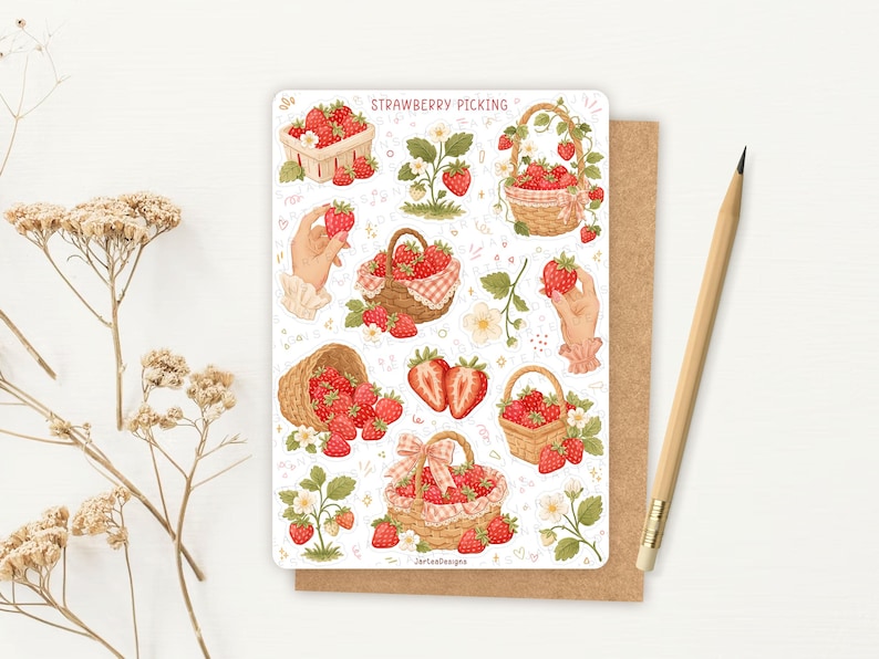 May include: A sticker sheet titled STRAWBERRY PICKING featuring various illustrations of red strawberries in woven baskets, a strawberry plant, and hands holding strawberries. The design includes small pink hearts and floral accents on a white background.