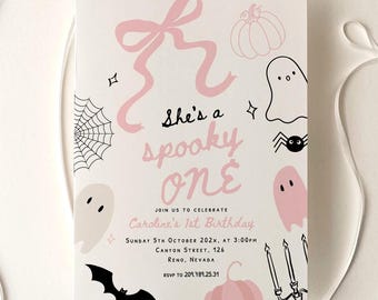 May include: A rectangular invitation card featuring a pink bow, ghosts, pumpkins, a spider web, and a bat. The text reads: She's a spooky one, join us to celebrate Caroline's 1st birthday, Sunday 5th October 202x, at 3:00pm, Canyon Street, 126, Reno, Nevada, rsvp to 209.789.25.31.
