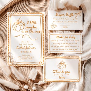 May include: A collection of baby shower stationery with a pumpkin theme. The invitation reads "A little pumpkin is on the way." Other cards include "Diaper Raffle," "Books for baby," and "Thank you." The design features a warm color palette.