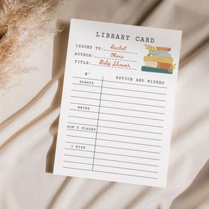 May include: A white library card with the text "Library Card" at the top. The card includes fields for "Issued To," "Author," and "Title." A stack of books illustration is on the right. The card is for a baby shower.