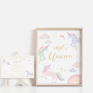 May include: A framed print with a white background and gold lettering that says "adopt a unicorn". The print features illustrations of four unicorns in pastel colors with rainbow accents.