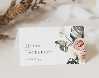 May include: A white place card with a floral design in shades of green, pink, and white. The text on the card reads "Jillian Hernandez Table Eight".