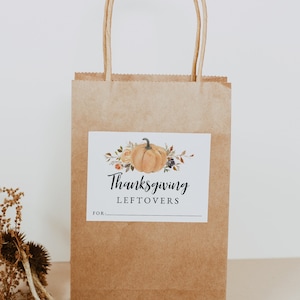 May include: A brown paper bag with a white label that says "Thanksgiving Leftovers" with a watercolor illustration of a pumpkin and fall foliage. The label has a blank space for "For:"