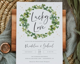 May include: A green shamrock wreath with gold glitter accents surrounds the text "Lucky in Love" on a white card. The card also includes details for an engagement party honoring Madeline & Gabriel on March 19th at 6:00 PM at The Thompson Residence, 5528 Willow Ridge Lane, Sacramento, CA. The party is hosted by Phil & Linda Thompson.