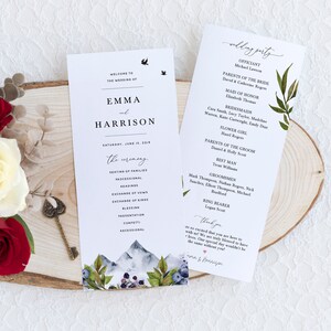 May include: Wedding ceremony program with a watercolor mountain and floral design. The program lists the order of events for the wedding ceremony of Emma and Harrison, which is taking place on Saturday, June 15, 2019. The program also includes a list of the wedding party members and their roles.