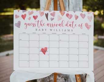 Puede incluir: Un calendario blanco con un diseño de corazón de acuarela rosa. El calendario está titulado "Adivina la fecha de llegada del bebé Williams". El calendario está configurado para junio y julio con un corazón que marca la fecha de parto.