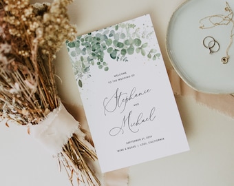 May include: Wedding invitation with a watercolor design of green eucalyptus leaves and white dots. The text reads "Welcome to the wedding of Stephanie and Michael, September 21, 2019, Wine & Roses | Lodi, California".