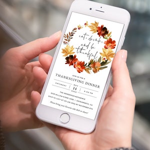 May include: A Thanksgiving dinner invitation on a smartphone screen with a wreath of fall leaves and flowers. The text reads "eat, drink, and be thankful." The invitation details include the date, time, location, and RSVP information.