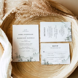 May include: Wedding invitation suite with a watercolor background featuring a mountain range and trees. The invitation card is white with black text and reads "Emma Robinson and Harrison Daniels" with the wedding date and location. The RSVP card is white with black text and includes a section for guests to indicate their attendance and meal choice.