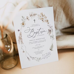 May include: A white card with a floral wreath border and a cross at the top. The text reads "Please join us as we celebrate the Baptism of our daughter Amelia Robertson, Sunday, September 12, 20XX at 11:00 AM, St. John's Church, Murfreesboro, TN, followed by lunch at Stones Creek Cafe, Murfreesboro, TN. Please RSVP to Sandra by September 1st, (000) 000-0000."