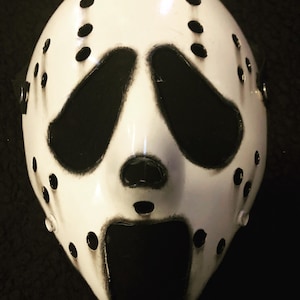 May include: A white hockey mask with black eye holes and a large open mouth. The mask has a distressed look with black paint splatters.