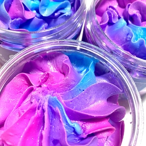 May include: Two clear glass jars filled with a swirl of pink and blue whipped body butter.