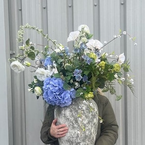 Arreglo floral de seda azul: Centro de hortensias en jarrón de piedra